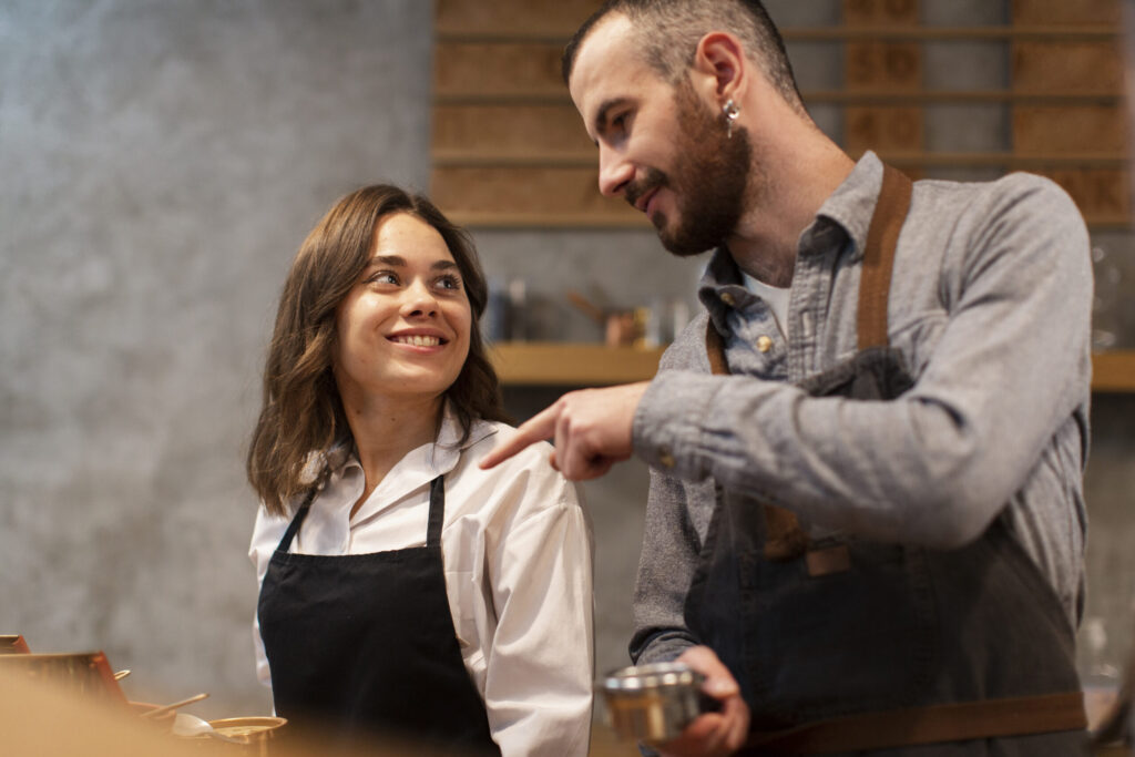 Two hospitality staff members working together smiling at eachother