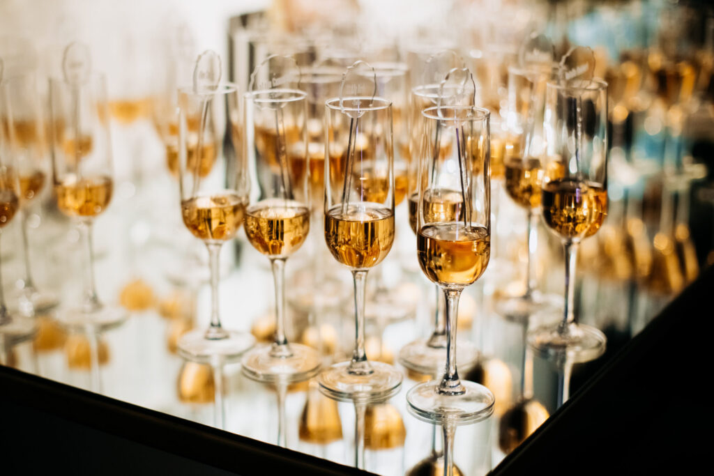 champagne glasses full alcohol drinks tray with mirror reflection at fancy event