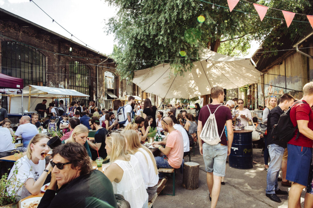 People eating and drinking at busy street market on Bank Holiday