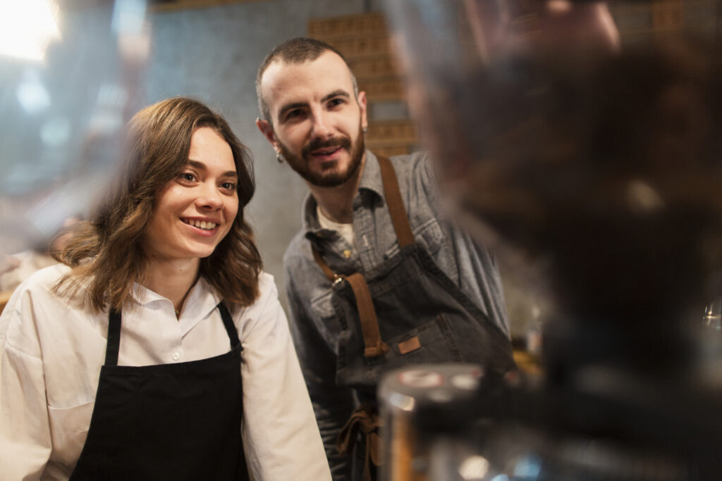 Smiling man and woman working in a coffee shop